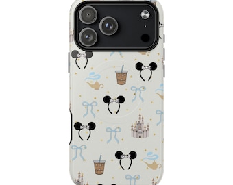 Puede incluir: Una funda de teléfono con un fondo crema que presenta un patrón repetido de orejas de ratón en forma de lazo negro, lazos azules, bebidas de café, lámparas de genio e ilustraciones de castillos. La funda tiene un módulo de cámara negro.