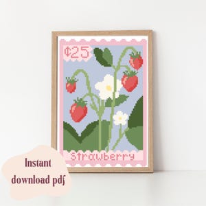 May include: A framed print featuring a pixelated strawberry design, resembling a postage stamp. The artwork showcases red strawberries, white flowers, and green leaves against a light blue background. The text "Strawberry" is at the bottom, with "$25" at the top.