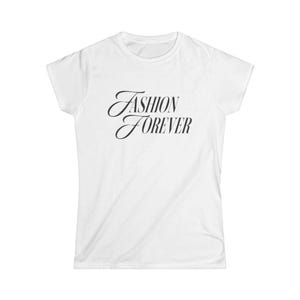 May include: A white short-sleeved t-shirt featuring the black text FASHION FOREVER printed in a stylized, slanted serif font across the center of the chest. The garment has a crew neckline and a standard fit with short sleeves and a straight hem.