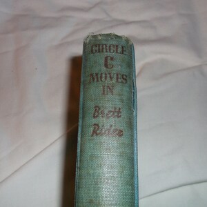 May include: A vintage book with a teal blue cover and the title "Circle C Moves In" by Brett Riddle.