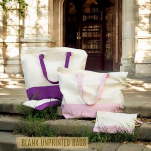 Two large tote bags with purple and pink accents are placed on a set of stone steps in front of a building with a bookshelf visible in the background.