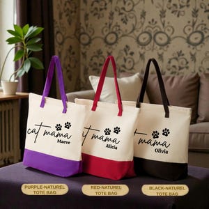 Three tote bags with the same design, each with a different color: purple, red, and black. The bags are placed on a table in front of a couch, with a plant in the background.