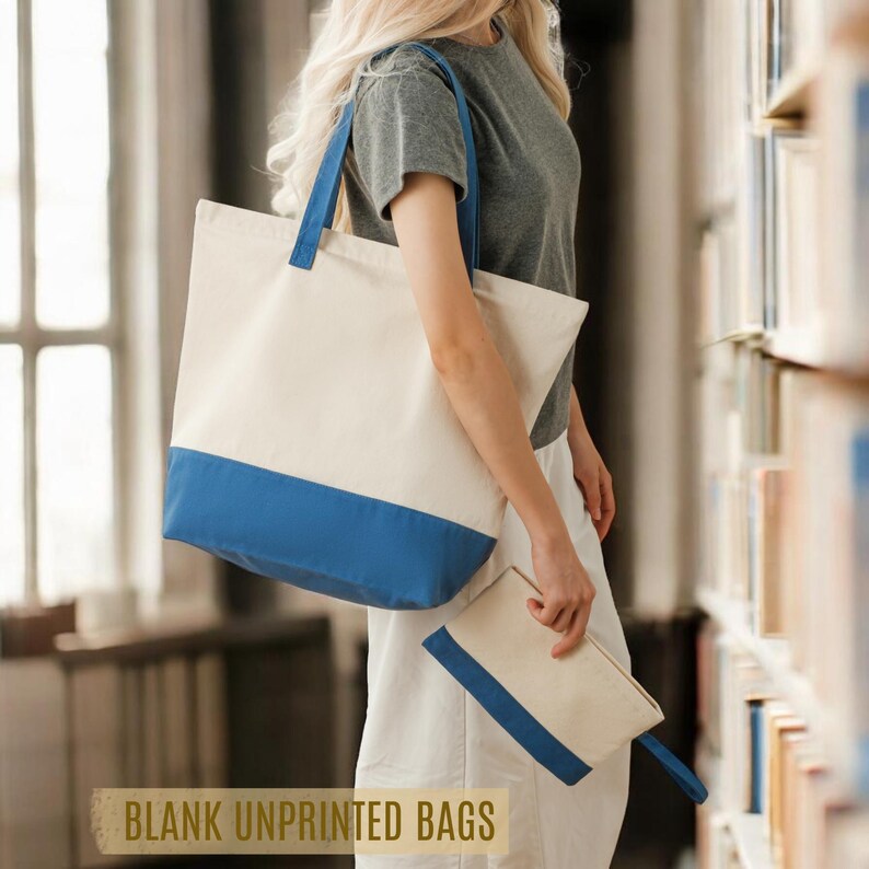 A woman is standing in a library, holding a large tote bag with a blue and white color scheme.
