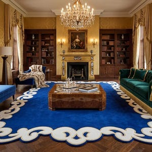 May include: A luxurious living room with a large blue rug featuring a white decorative border. The room includes a green sofa, blue chaise lounges, a wooden coffee table, and a fireplace. A chandelier hangs from the ceiling.
