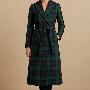 Könnte beinhalten: Ein langer, grün-blauer karierter Mantel mit passendem Gürtel. Der Mantel hat einen klassischen Reverskragen und lange Ärmel. Das Model trägt schwarze Stiefel.