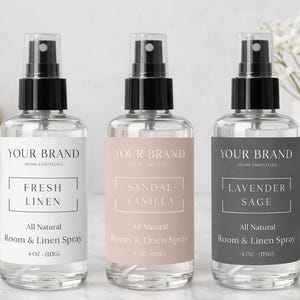 以下が含まれることがあります： 「Fresh Linen」、「Sandal Vanilla」、および「Lavender Sage」と書かれたラベルが付いた、黒いスプレーキャップが付いた3つの透明なガラススプレーボトル。「Your Brand Home Essentials」と「All Natural Room & Linen Spray」とラベル付けされています。各ボトルには118 mlが含まれています。