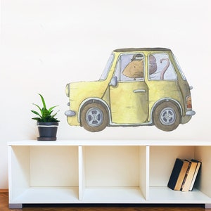 Op de afbeelding: Een gele auto met een open deur en een muis met een hoed die rijdt. De auto bevindt zich op een witte muur met een plank eronder.