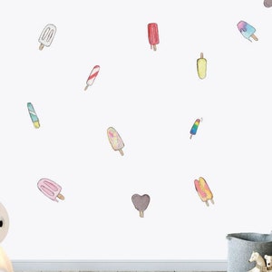 May include: A white wall with a variety of colorful popsicle stickers. The stickers are in different shapes and sizes, and some have stripes or swirls.