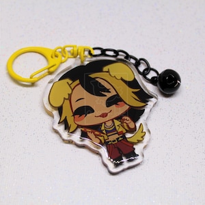 May include: An acrylic keychain featuring a cartoon character with yellow dog ears, black hair, and a yellow jacket, attached to a yellow plastic clasp and a black chain with a small black bell. The top left corner displays a bird logo and the text a-happy-Jake.