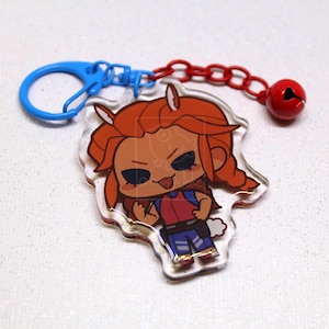 May include: An acrylic keychain featuring a cartoon character with orange hair, a red shirt, and blue pants. The charm is attached to a blue plastic ring and a red chain with a small red bell. The logo a-happy-Jake is visible in the corner.