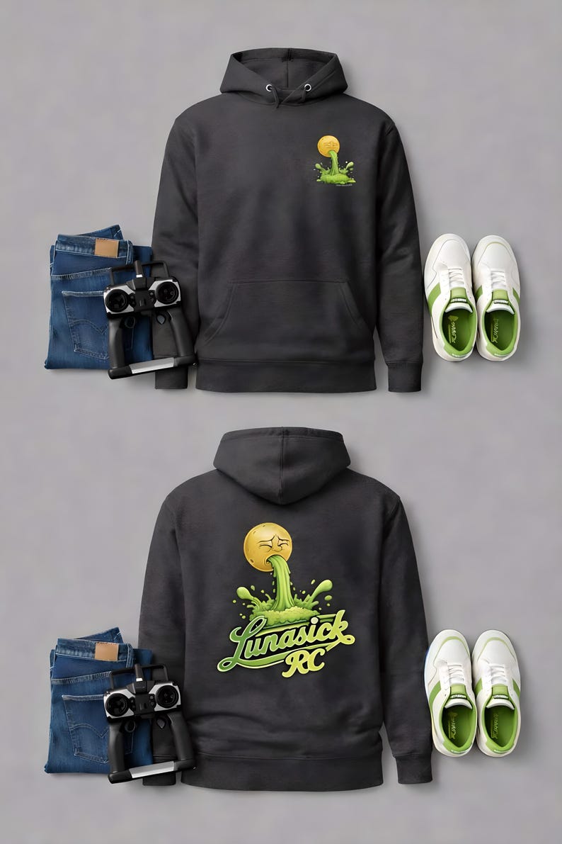 Peut inclure: Un sweat &agrave; capuche gris fonc&eacute; avec une poche avant et une capuche, orn&eacute; d'un motif d'emoji jaune vomissant du liquide vert. Le dos du sweat affiche le texte "Lunasick RC". L'image comprend &eacute;galement un jean bleu, une t&eacute;l&eacute;commande et des baskets blanches.