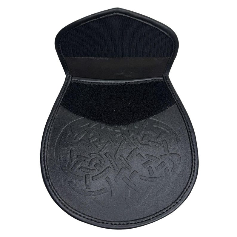 Peut inclure: Sporran en cuir noir avec un motif de n&oelig;ud celtique. Le sporran a une fermeture &agrave; rabat avec une bande Velcro et un dos en tissu noir. Le bas du sporran est arrondi.