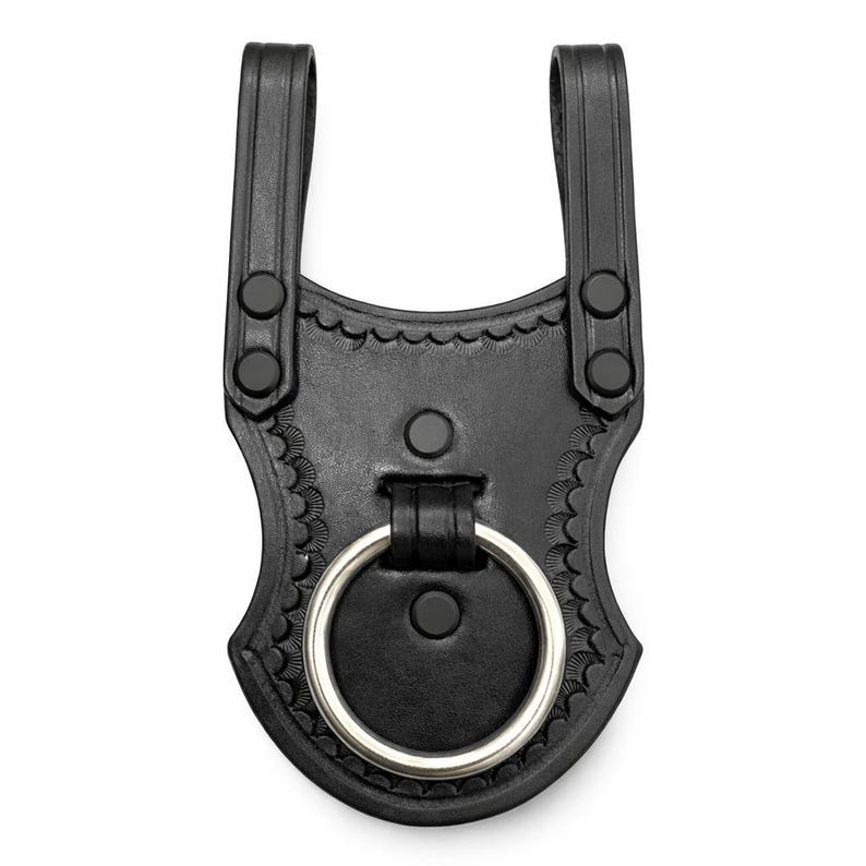 May include: Black leather belt loop with a decorative scalloped edge and a silver-colored metal ring. The loop has two vertical straps with black snap closures and is designed to attach to a belt. The item is shown against a white background.