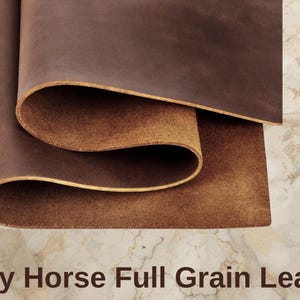 May include: Close-up of rolled brown Crazy Horse full-grain leather. The leather has a rich, textured appearance with variations in color, showcasing its natural grain. The edges of the leather are visible, highlighting its thickness and quality.