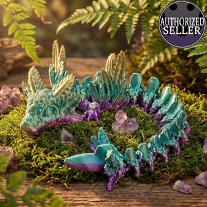 Puede incluir: Una figura de dragón de fantasía en tonos turquesa, morado y crema, sobre un lecho de musgo verde con cristales de amatista. El dragón tiene un diseño detallado y texturizado. La imagen incluye un sello "AUTHORIZED SELLER".