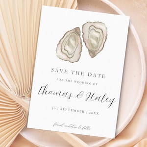 Puede incluir: Una invitación de boda blanca con ilustraciones de ostras en acuarela. El texto dice "SAVE THE DATE" y anuncia la boda de Thomas & Haley, con la fecha "30 | SEPTIEMBRE | 20XX".