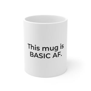 Peut inclure: Mug en céramique blanche avec l'inscription "This mug is BASIC AF." en noir. Le mug est cylindrique et semble vide. Un objet simple et quotidien.