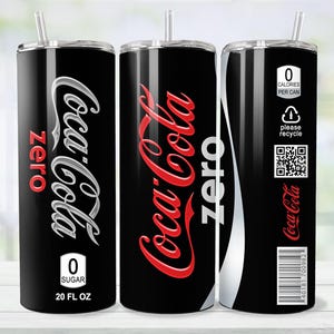 May include: A black tumbler with a silver lid and straw, featuring the Coca-Cola Zero logo in red and white. The tumbler has the text "0 Sugar" and "20 FL OZ". The design includes a white stripe and a QR code.