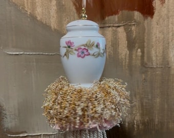 Salero de porcelana artesanal con forma de flores de cerezo y borla decorativa, estilo vintage.
