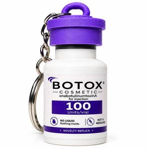 May include: A white novelty keychain shaped like a Botox Cosmetic vial with a purple cap. The label reads BOTOX COSMETIC onabotulinumtoxinA for injection 100 Units/vial, NO LIQUID Nothing inside, NOT A MEDICINE, and NOVELTY REPLICA with icons.