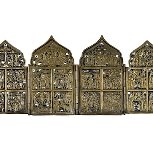 May include: A detailed, antique brass religious icon with four hinged panels. Each panel features intricate relief carvings depicting biblical scenes and figures. The icon has a decorative, arched top.