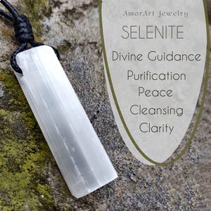 A raw, rectangular selenite pendant hangs from a black cord necklace, positioned on a textured gray stone surface with green and brown moss. To the right, stylized text reads "SELENITE," and lists "Divine Guidance," "Purification," "Peace," "Cleansing," and "Clarity." This selenite necklace is associated with spiritual connection and cleansing.
