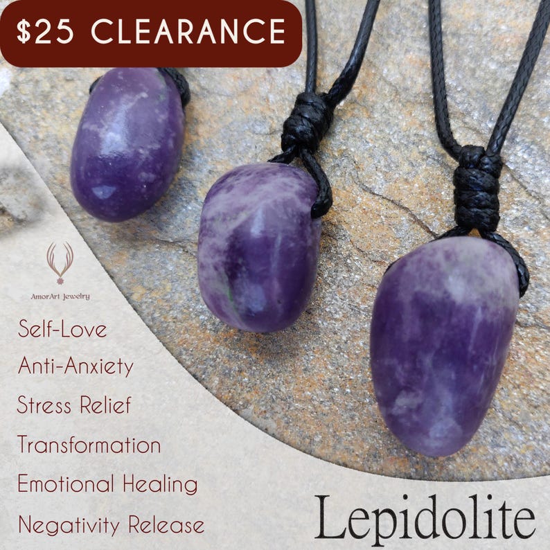 Three smooth, polished, irregular oval Lepidolite necklace pendants are displayed on a textured gray concrete surface. The purple gemstones vary slightly in color intensity and show some lighter patches and subtle striations. Each pendant is attached to a black cord. Text on the image identifies the stone as "LEPIDOLITE" and lists its associated qualities: "Self-Love", "Anti-Anxiety", "Stress Relief", "Transformation", "Emotional Healing", and "Negativity Release".