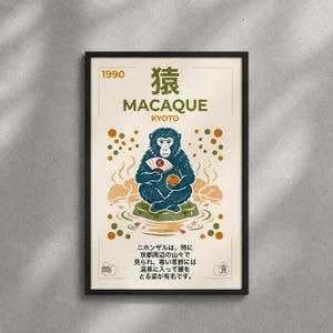 May include: Framed poster featuring a blue macaque monkey holding a fan and an orange, with text that reads "MACAQUE KYOTO 1990". The illustration is set against a cream background with orange and brown accents, and Japanese text.