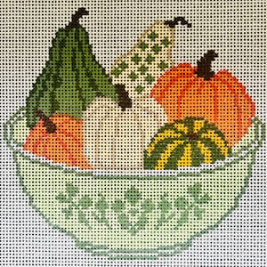 May include: A needlepoint canvas featuring a light green bowl with a delicate floral pattern, filled with a variety of colorful gourds and pumpkins in shades of orange, dark green, and cream, all set against a white grid background.