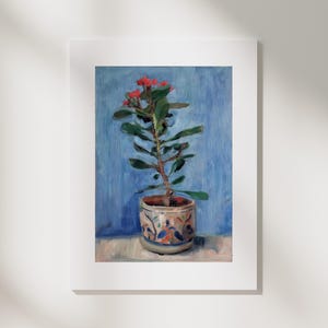 Può includere: Dipinto a olio di una pianta in vaso con fiori rossi e foglie verdi. La pianta è in un vaso decorativo con un motivo blu e arancione. Lo sfondo è un lavaggio blu e il dipinto è incorniciato in bianco.