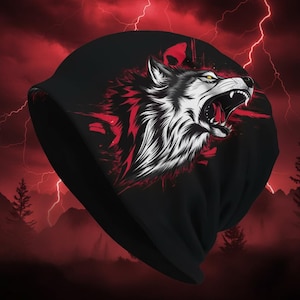 Puede incluir: Gorro negro con una ilustración detallada de un lobo gruñendo. El lobo tiene pelaje blanco, detalles rojos y ojos amarillos. El diseño está sobre un fondo rojo con relámpagos y una silueta de montaña.