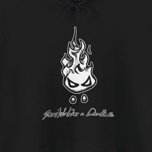 May include: Black hoodie with a white flame graphic, featuring a face, and the text "Scribblits n Doodles". The hoodie has a drawstring hood and a kangaroo pocket.