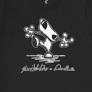 Peut inclure: T-shirt noir avec un dessin de personnage de dessin animé blanc et stylisé. Le personnage a un long nez et les bras tendus. Le texte "Scribblits n Doodles" est écrit en cursive au bas du t-shirt.