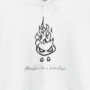 May include: White hoodie with a black doodle of a flame with eyes and two dots beneath. The cursive text "Scribblits n Doodles" is below the flame design. The hoodie has a drawstring hood.