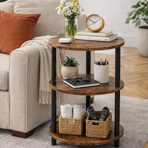 May include: A three-tiered round side table with a dark brown wood grain finish and black metal supports. The top shelf holds a vase of flowers, a clock, and books. The lower shelves display baskets and other items. A stylish accent piece.