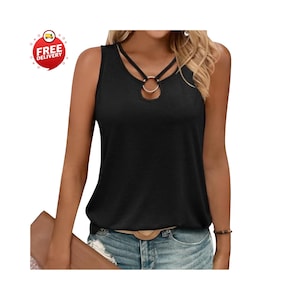 May include: Black sleeveless top with a distinctive neckline. The top has a gold-coloured ring detail and a keyhole cutout. It is worn with denim shorts. A "Free Delivery" sticker is in the upper left corner.