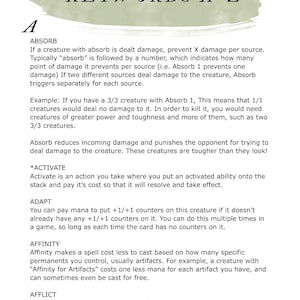 Puede incluir: Una página de una guía de referencia titulada "KEYWORDS A-Z" con definiciones de términos de juego como "Absorb", "Activate", "Adapt", "Affinity" y "Afflict". La página tiene un diseño de acuarela verde y beige.