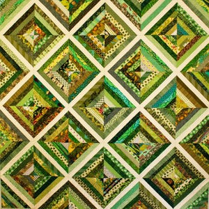 May include: A handmade quilt featuring a patchwork design with various shades of green fabrics. The quilt is composed of square blocks, each divided into diamond shapes with diagonal stripes. The color palette includes olive, lime, and forest green.