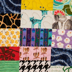 May include: A colorful patchwork quilt with a variety of patterns, including floral, geometric, and animal prints. The quilt is made up of squares of different fabrics sewn together.