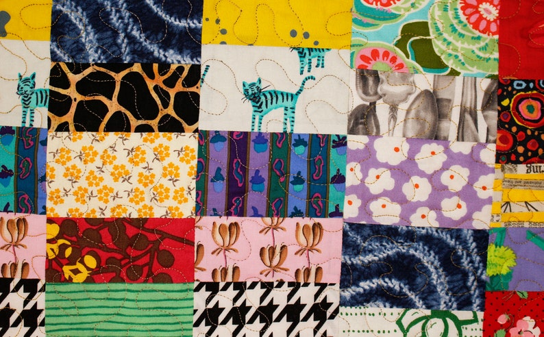 May include: A colorful patchwork quilt with a variety of patterns, including floral, geometric, and animal prints. The quilt is made up of squares of different fabrics sewn together.