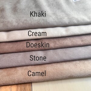 May include: Five stacked fabric swatches with a soft, suede-like texture in neutral tones. The labels printed on the fabric are Khaki, Cream, Doeskin, Stone, and Camel. Each layer shows a distinct shade of beige, tan, or light brown in a horizontal arrangement.