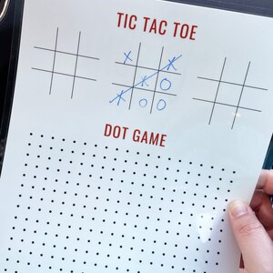 May include: A white sheet of paper with a black grid for a tic-tac-toe game. The game is partially played with blue X's and O's. Below the tic-tac-toe game is a black and white dot game.