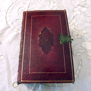 Antico libro di preghiere e devozione religiosa francese del 1818, con pagine dorate, copertina in pelle, litografie raffiguranti Gesù, la natività e la sacra famiglia.