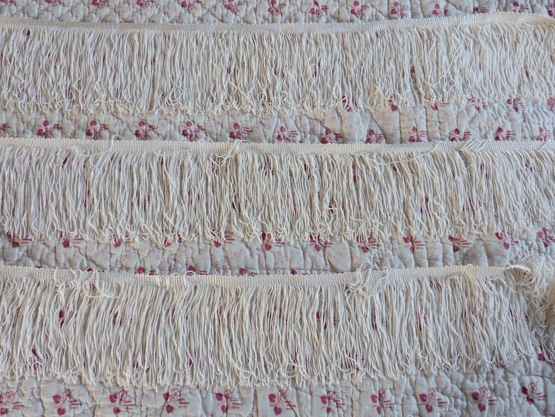 May include: Three rows of white fringe trim, each row is about 1 inch wide. The fringe is made of a soft, white yarn and is perfect for adding a touch of elegance to any project.