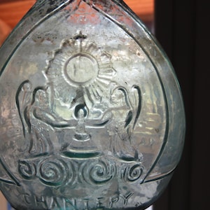 Antique French green glass bottle, religious holy water bottle loupe for lace makers w saint Francois Regis, angels, chalice, cross,