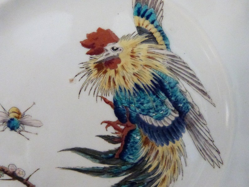 May include: A detailed painting of a rooster with blue, yellow, and red feathers. The rooster is perched on a branch with a bee flying nearby.