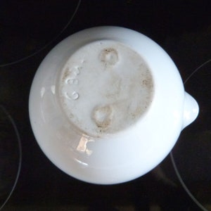 May include: White ceramic bowl with a small spout. The bottom of the bowl has a mark that reads "236".