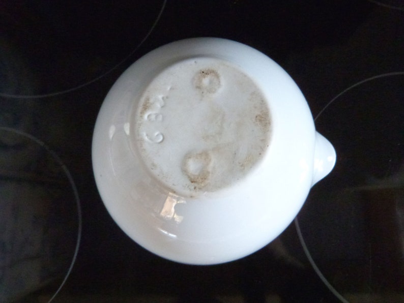 May include: White ceramic bowl with a small spout. The bottom of the bowl has a mark that reads "236".