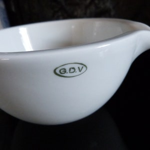 May include: White porcelain bowl with a green oval logo that reads "G.D.V."