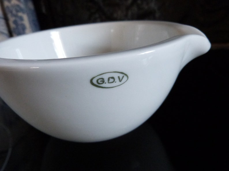 May include: White porcelain bowl with a green oval logo that reads "G.D.V."